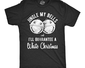 May include: A charcoal gray short-sleeve t-shirt featuring a white distressed graphic of two jingle bells. The text reads JINGLE MY BELLS and I'LL GUARANTEE A White Christmas in a mix of bold block and script fonts centered on the chest.