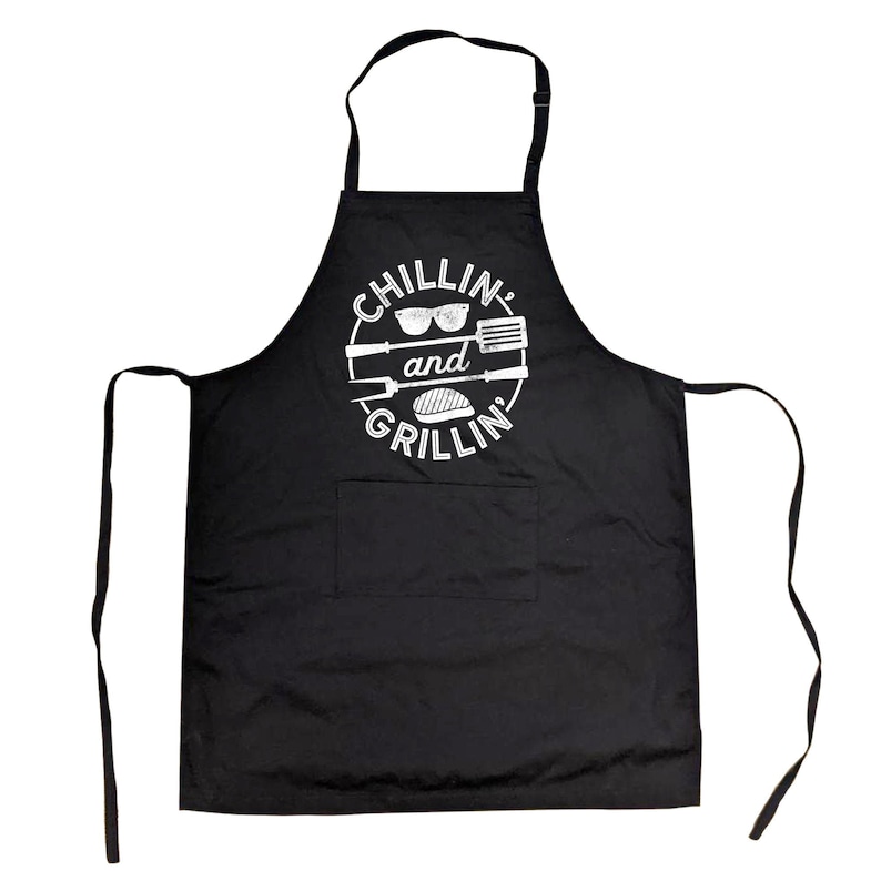 May include: Black apron with a white circle design that says "Chillin' and Grillin'" with sunglasses, a spatula, a fork, and a hamburger inside the circle.