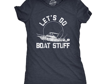 Op de afbeelding: Een donkerblauw gemêleerd T-shirt met korte mouwen en een witte, verweerde afbeelding van een motorboot en een cirkelvormige zon. De tekst "LET'S DO BOAT STUFF" is in een vet, verweerd wit lettertype boven en onder de boot gedrukt.