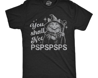 May include: A black short-sleeved t-shirt featuring a graphic of a cat dressed as a wizard, holding a staff. The text reads "You shall Not PSPSPSPS" in a distressed white font, accompanied by small star illustrations surrounding the cat figure.