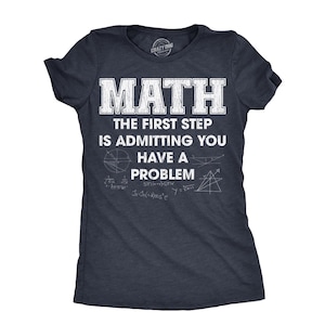 May include: A dark navy blue short-sleeve t-shirt featuring white distressed text that reads MATH THE FIRST STEP IS ADMITTING YOU HAVE A PROBLEM, accompanied by various white mathematical diagrams and equations printed on the front chest area.