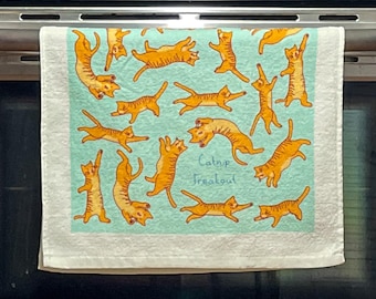 May include: A light mint green kitchen towel featuring a repeating pattern of orange tabby cats in various playful poses. The text Catnip Freakout is printed in the center in a casual blue script. The towel has a solid white border.