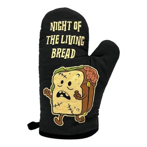 May include: A black oven mitt featuring the text "NIGHT OF THE LIVING BREAD" in yellow letters. Below the text is a graphic of a cartoon slice of bread designed as a zombie with stitches, a brain exposed on the side, and brown limbs.
