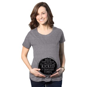 May include: A gray maternity t-shirt with a black circle graphic that says "Hello from the inside I must have kicked a thousand times".