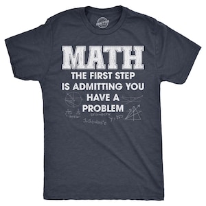 May include: A dark navy blue short-sleeved t-shirt featuring white distressed text that reads MATH THE FIRST STEP IS ADMITTING YOU HAVE A PROBLEM. Below the text are various white mathematical equations and geometric diagrams printed on the chest.