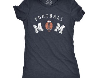 Op de afbeelding: Een donkerblauw gemêleerd T-shirt met korte mouwen en de witte, verweerde tekst FOOTBALL MOM op de borst gedrukt. De letter O in het woord MOM is vervangen door een bruine en witte grafische illustratie van een American football.