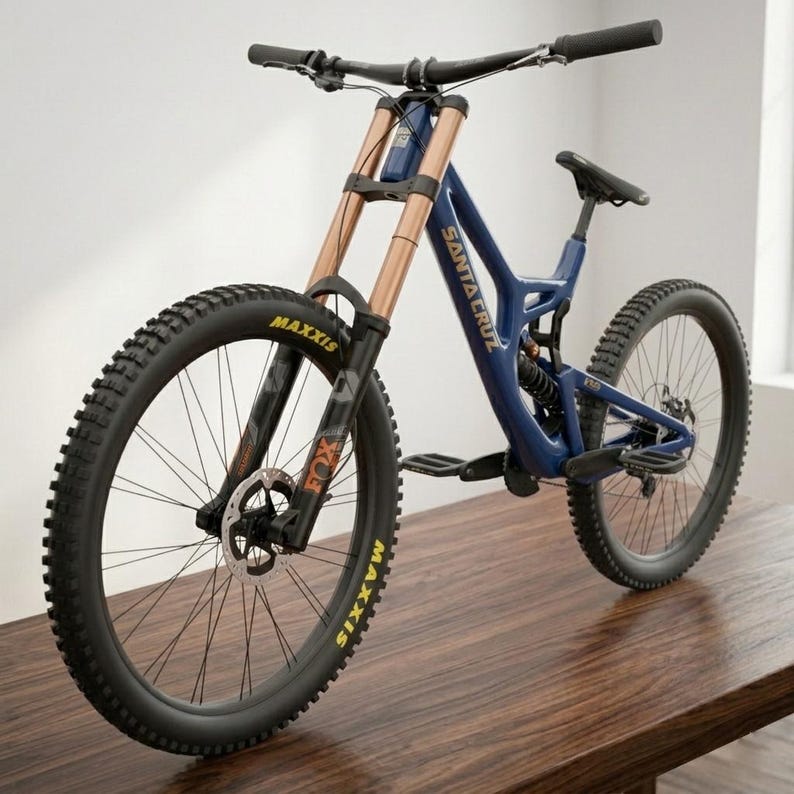 May include: A blue and copper mountain bike with the text "SANTA CRUZ" on the frame. The bike has black tires with yellow lettering, a black seat, and a suspension fork. The bike is on a wooden surface.