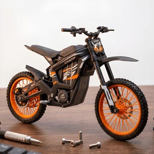 Op de afbeelding: Een zwart-oranje speelgoedmotor met het woord "CHAMP" op de zijkant. De motor heeft oranje wielen en accenten, een zwart zadel en een voorspatbord. De banden hebben een noppenprofiel. De motor staat op een houten oppervlak.