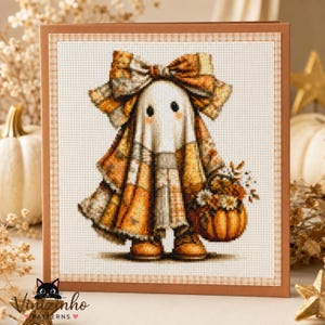 May include: A cross-stitch pattern card featuring a ghost character wearing a large plaid bow and a plaid cloak in shades of orange, brown, and cream. The ghost holds a small basket filled with autumn flowers and a pumpkin, set against a grid background.