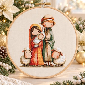 Könnte beinhalten: Ein runder Stickrahmen aus Holz mit einem Kreuzstichmotiv einer Krippenszene. Das Bild zeigt eine Figur in einem roten Gewand, die ein Baby hält, eine Figur in einem grünen Gewand sowie zwei weiße Schafe in einem weichen Illustrationsstil.
