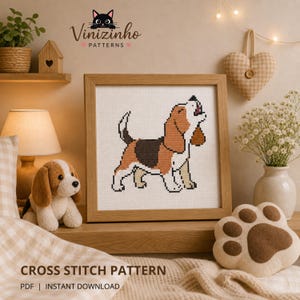 Peut inclure: Un motif de point de croix encadré d'un chien beagle marron, noir et blanc. L'image est dans un cadre en bois et est exposée sur une étagère avec un jouet en peluche pour chien et un coussin en forme de patte. Le texte "CROSS STITCH PATTERN" est en bas.