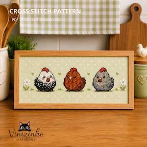 Op de afbeelding: Een ingelijst kruissteekpatroon met drie cartoonkippen in zwart, bruin en grijs, elk met een rode kam. De achtergrond is lichtgroen met witte stippen. De tekst "CROSS STITCH PATTERN" en "PDF INSTANT DOWNLOAD" staat bovenaan.
