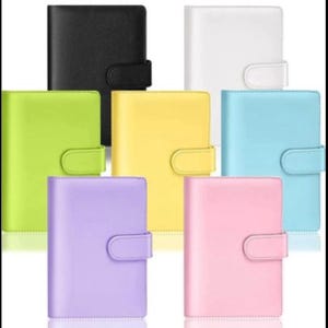 May include: A collection of colorful, leather-like binders in various shades, including black, white, green, yellow, blue, purple, and pink. Each binder features a rounded flap closure. These binders are suitable for organizing notes, documents, or personal items.