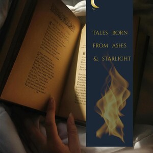 Peut inclure: Un livre ouvert aux pages jaunies et vieilles, affichant du texte manuscrit. Un marque-page bleu foncé avec le texte "TALES BORN FROM ASHES & STARLIGHT" et un croissant de lune est visible. Une main tient le livre.