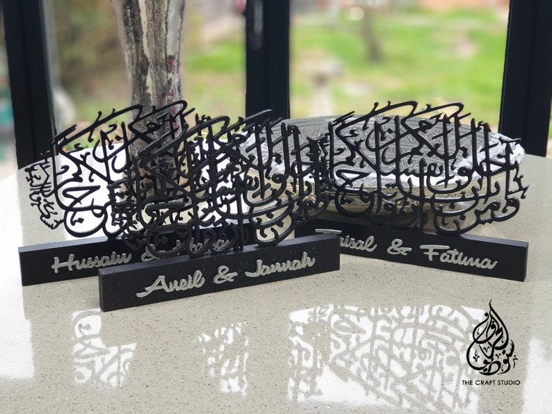 May include: Three black wooden plaques with Arabic calligraphy designs and personalized names. The names on the plaques are "Hussain", "Avel & Jannah", and "Trisal & Fatima".