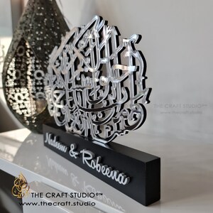 Op de afbeelding: Een zilveren en zwarte decoratieve plaquette met Arabische kalligrafie en de namen Nadeem & Robeena. De plaquette staat op een zwarte basis met de tekst "THE CRAFT STUDIO&trade;" en "www.thecraft.studio" aan de onderkant.