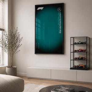 Puede incluir: Una pieza de arte mural rectangular de vidrio con un fondo degradado en color verde azulado oscuro, el logotipo F1 en blanco en la esquina superior izquierda y el logotipo Mercedes-AMG Petronas impreso verticalmente en blanco a la derecha.