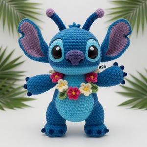 May include: A handmade blue crochet Stitch doll with large ears, a purple nose, and a floral lei. The doll has large black eyes and the number "626" is visible. The doll is approximately 10 inches tall.