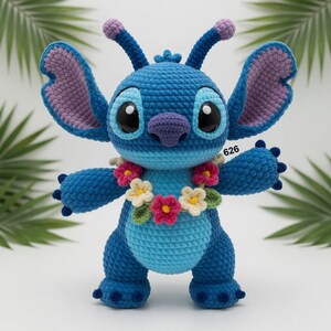 May include: A handmade blue crochet Stitch doll with large ears, a purple nose, and a floral lei. The doll has large black eyes and the number "626" is visible. The doll is approximately 10 inches tall.
