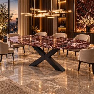 Op de afbeelding: Een ovale eettafel met een gepolijst blad van donkerrood en zwart marmer met opvallende witte aders, ondersteund door een stevig zwart metalen X-vormig onderstel. De tafel is omringd door zes beige gestoffeerde stoelen met zwarte poten.