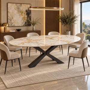 Op de afbeelding: Een ovale eettafel met een wit en goudkleurig marmeren blad en een zwart metalen X-vormig onderstel, omringd door zes gestoffeerde stoelen met beige stoffen zittingen en donkerhouten rugpanelen, geplaatst op een lichtgekleurd vloerkleed.