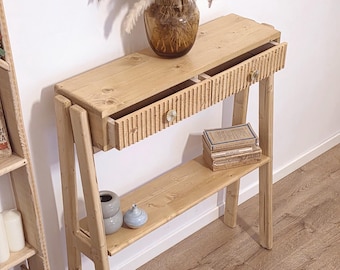 Consolle artigianale in legno naturale con ripiano e frontale scanalato.