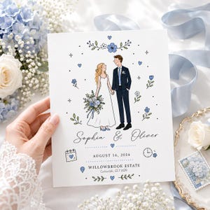 Puede incluir: Una tarjeta de invitación de boda blanca con una ilustración de una pareja tomados de la mano, rodeada de flores azules y corazones. El texto dice Sophia & Oliver, 16 de agosto de 2026, y Willowbrook Estate, Cotswolds, GL7 6QN, con iconos.
