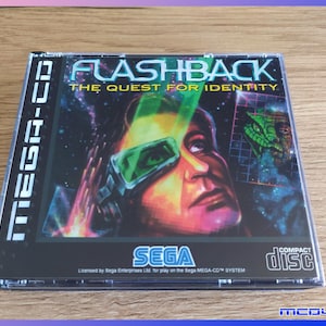 Könnte beinhalten: SEGA Mega-CD-Spielhülle für "Flashback: The Quest for Identity". Das Cover zeigt eine futuristische Illustration eines Mannes mit futuristischer Brille und einer grünen reptilienartigen Kreatur im Hintergrund. Die Hülle ist mit "MEGA-CD" und "COMPACT DISC" beschriftet.
