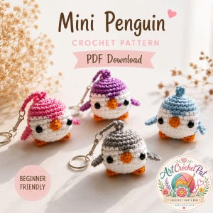 May include: Four crocheted mini penguin keyrings in pink, purple, blue, and grey. Each penguin has a white body, orange feet, and black eyes. The image includes text that reads "Mini Penguin Crochet Pattern PDF Download".
