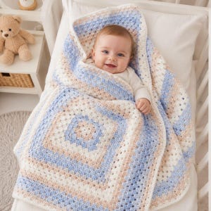May include: A handmade crochet baby blanket featuring a square pattern in alternating stripes of soft blue, cream, and light beige yarn. The blanket is constructed with a classic granny square stitch design, creating a textured, open-weave appearance.