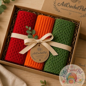 May include: A gift box containing three rolled crochet items in red, orange, and green, tied with a beige ribbon and a tag that reads "ArtCrochet Pat Handmade With Love." The box is brown and has the text "ArtCrochet Pat Handmade Crochet Patterns."