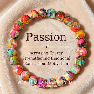 May include: A vibrant beaded bracelet with the word "Passion" displayed. The beads are spherical and multi-coloured, with shades of red, yellow, blue, and pink. Text below reads "Increasing Energy, Strengthening Emotional Expression, Motivation."