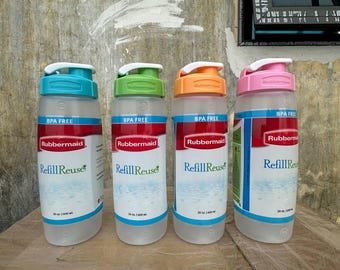 May include: Four translucent plastic water bottles with flip-top lids in teal, green, orange, and pink. Each bottle features a white label with the Rubbermaid logo, the text RefillReuse, and the specification 20 oz. 600 ml. All are BPA free.