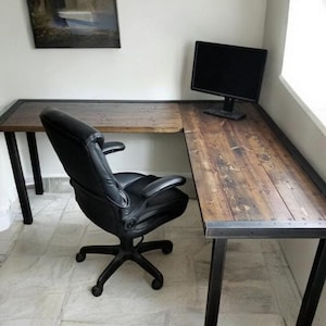 May include: A dark wood L-shaped desk with black metal legs. The desk has a rustic finish and is paired with a black office chair.