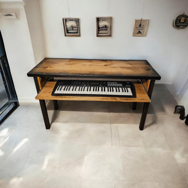 May include: A black metal keyboard stand with a wooden top and a black keyboard on top of it. The stand has a shelf underneath the keyboard.