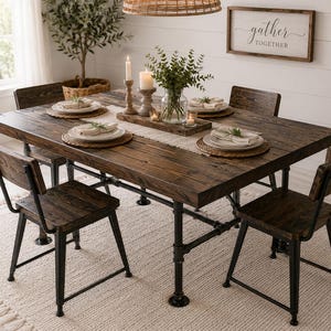 May include: A rectangular dining table with a dark brown wood top and black metal pipe legs, accompanied by four matching chairs with wood seats and black metal frames. The table is set with white plates, woven placemats, and a centerpiece.