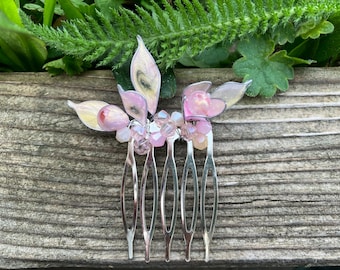 Peineta pequeña de color plata y rosa.