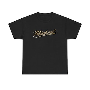 Op de afbeelding: Zwart T-shirt met de naam "Michael" in gouden script over de borst. Het shirt is gemaakt van zacht materiaal en heeft een klassieke ronde hals. Een casual en comfortabel kledingstuk.