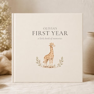 Puede incluir: Un libro de recuerdos cuadrado con tapa dura de color crema. La portada presenta el texto "OLIVIA'S FIRST YEAR a little book of memories" en letras gris oscuro, centrado sobre una ilustración en acuarela de una jirafa flanqueada por pequeñas hojas verdes.