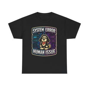 May include: Black t-shirt featuring a cartoon dog with a red bandana, designed with a "System Error" and "Human Issue" theme. The graphic includes text and digital-style elements, creating a humorous and tech-inspired design.