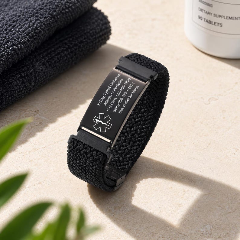 May include: A black medical alert bracelet with a woven nylon band and a rectangular metal plate. The plate features a white Star of Life symbol and engraved text: Kelsey, Type 2 Diabetes, Allergic to Penicillin, ICE: Chris 123-456-7890, Stacy: 098-765-4321, See Wallet for Meds.