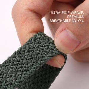 May include: A dark olive green nylon strap featuring an ultra-fine weave pattern. The material is described as premium, breathable nylon. The strap has a textured, braided appearance with a consistent, dense construction throughout the visible surface.