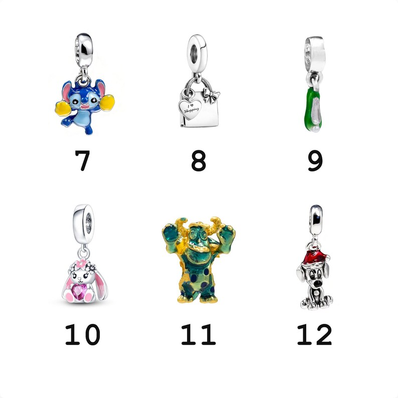 May include: A collection of six silver charms featuring a blue alien with yellow pom-poms, a shopping bag with a heart, a green shoe, a white rabbit with a pink heart, a green and blue monster, and a dog wearing a red Santa hat.
