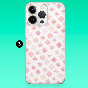 May include: A clear phone case featuring a repeating pattern of pink and peach-colored squares. Each square contains a cartoon character, heart, or star. The phone case is designed to fit a smartphone with three camera lenses.