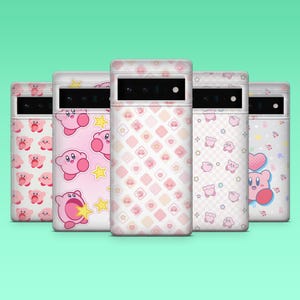 May include: Five phone cases with various pink and white designs featuring a cartoon character. The cases have different patterns, including the character's face, stars, and geometric shapes. The cases are displayed against a teal background.
