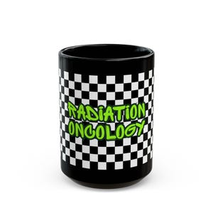 May include: Black ceramic mug with a checkered pattern in black and white. The words "RADIATION ONCOLOGY" are printed in green, outlined in black, across the center of the mug. The mug has a glossy finish.