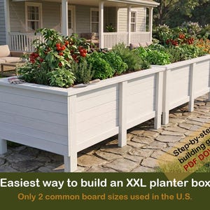 May include: Two white rectangular wooden planter boxes on legs, filled with green herbs and tomato plants. Text overlay reads: Step-by-step building guide PDF DOWNLOAD. Easiest way to build an XXL planter box! Only 2 common board sizes used in the U.S.