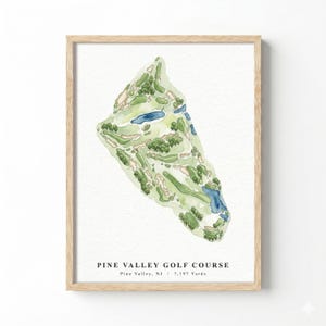 Puede incluir: Impresión en acuarela enmarcada del campo de golf Pine Valley en Nueva Jersey. El diseño del campo se muestra en tonos verdes, beige y azul, con árboles y elementos acuáticos. El marco es de madera clara.