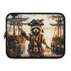 Könnte beinhalten: Eine rechteckige Laptoptasche mit einer Grafik eines Waschbären, der als Pirat mit Hakenhand, Augenklappe und Dreispitz verkleidet ist. Der Waschbär steht auf einem Holzsteg zwischen zwei Segelschiffen bei Sonnenuntergang und hält eine Schatzkarte.