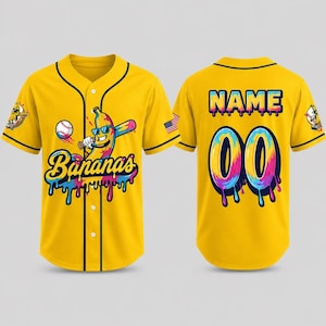 Pode incluir: Duas camisas de beisebol amarelas. A camisa da frente tem uma banana de desenho animado usando &oacute;culos de sol e segurando um taco de beisebol. O texto "Bananas" est&aacute; abaixo da banana. A camisa de tr&aacute;s tem o texto "NAME" e o n&uacute;mero "00" em um design colorido e gotejante.